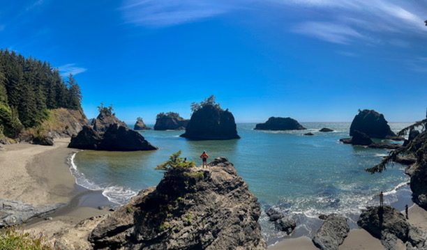 A panoramic view of sea stacks rising from the ocean at the picturesque Secret Beach along the Samuel H. Boardman State Scenic Corridor.